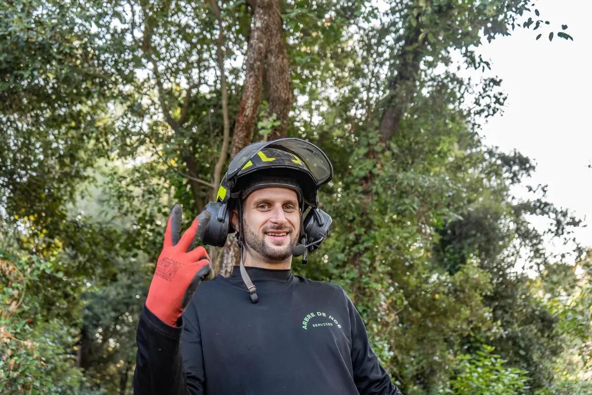 Élagueur casqué saluant sur un chantier dans les Alpes-Maritimes